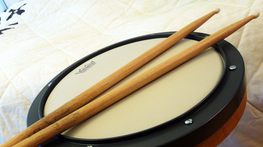 Pad de bateria e um par de baquetas: equipamento necessário para treinar rudimentos de bateria