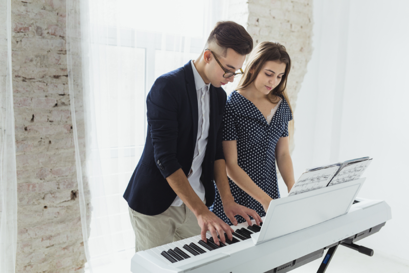 Jovem casal toca teclado para iniciantes