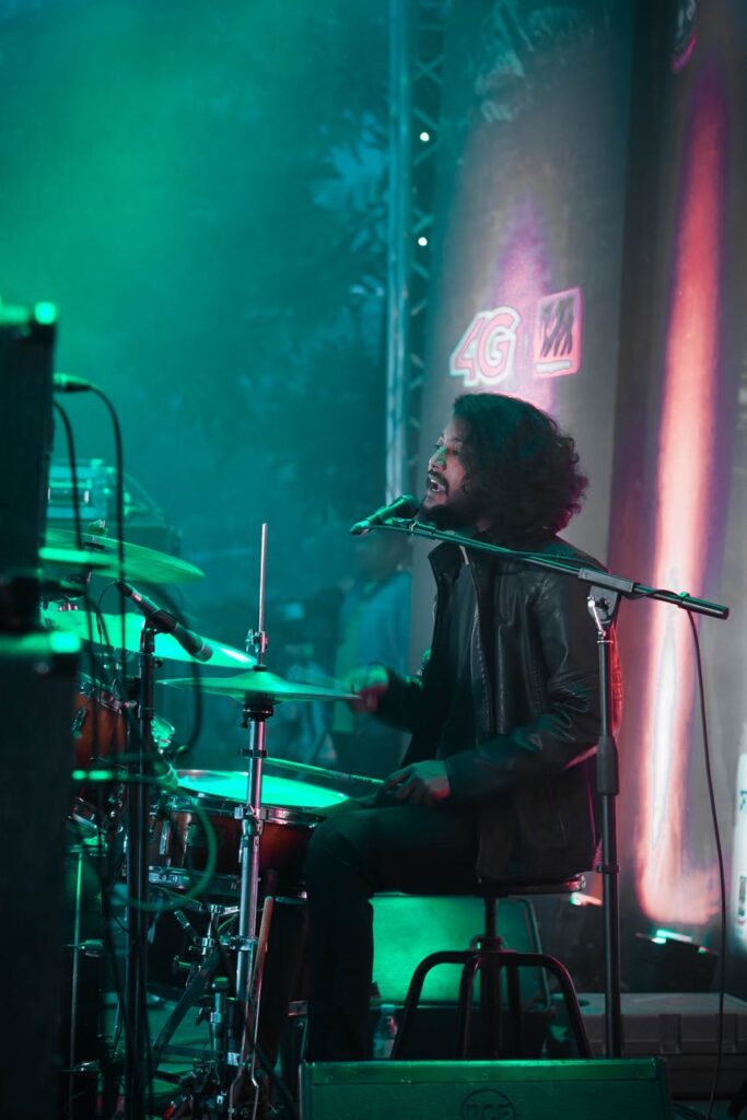 Baterista toca e canta ao mesmo tempo, durante apresentação