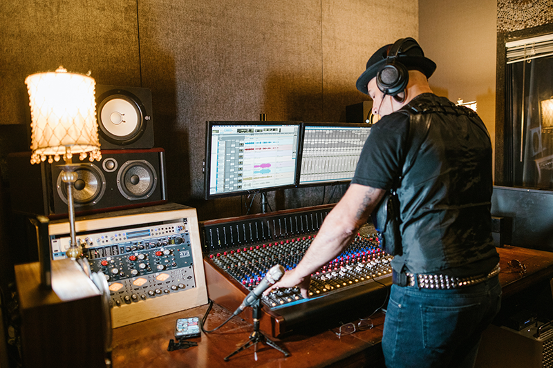 Productor musical mezclando las pistas en su set de estudio