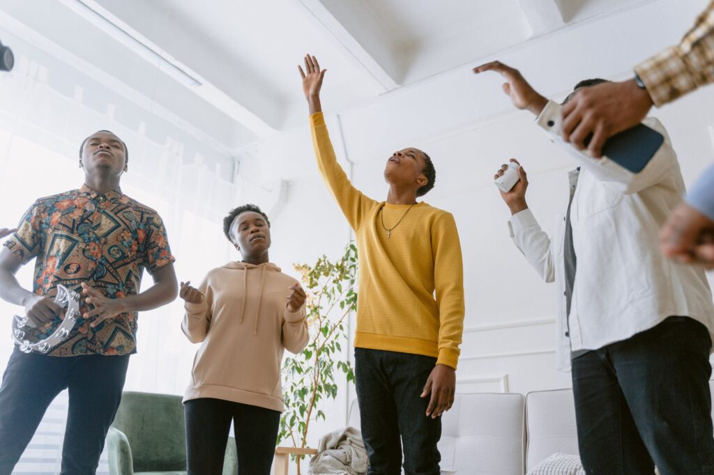 Jovens negros cantam música gospel, durante culto cristão