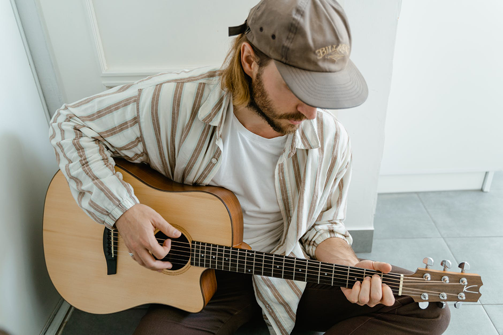 Músico tocando os dedilhados mais famosos no violão