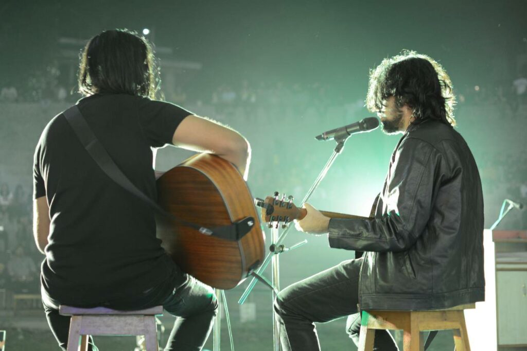 Dois músicos tocando com equipamentos para voz e violão