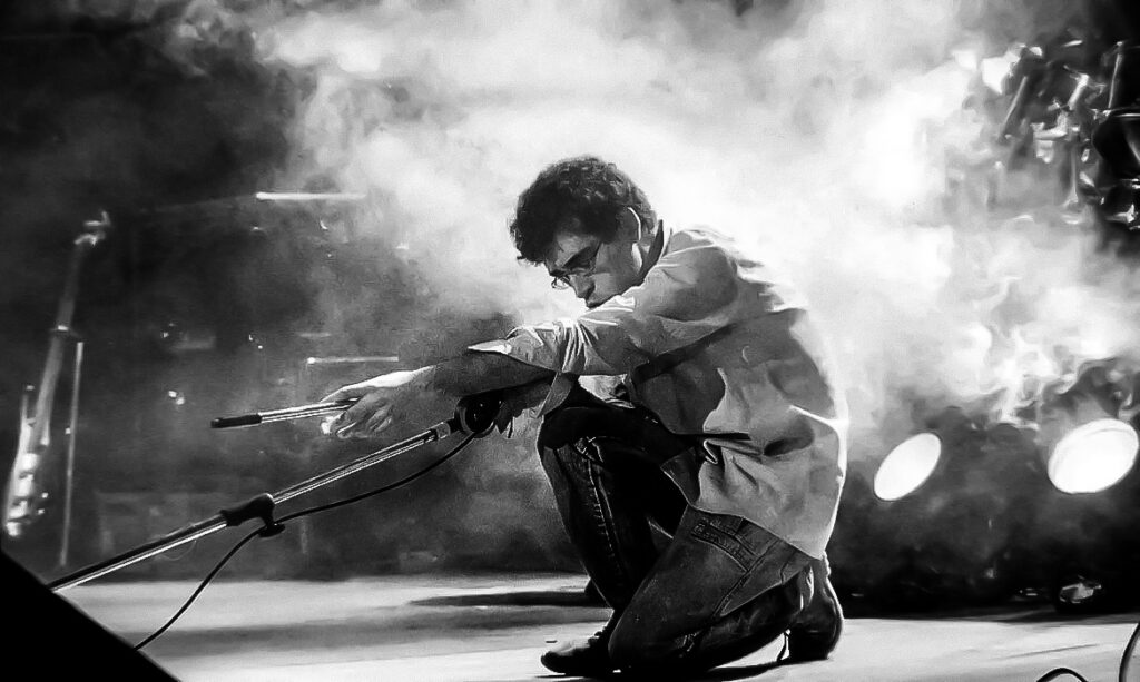 Renato Russo de joelhos no palco, durante show da Legião Urbana