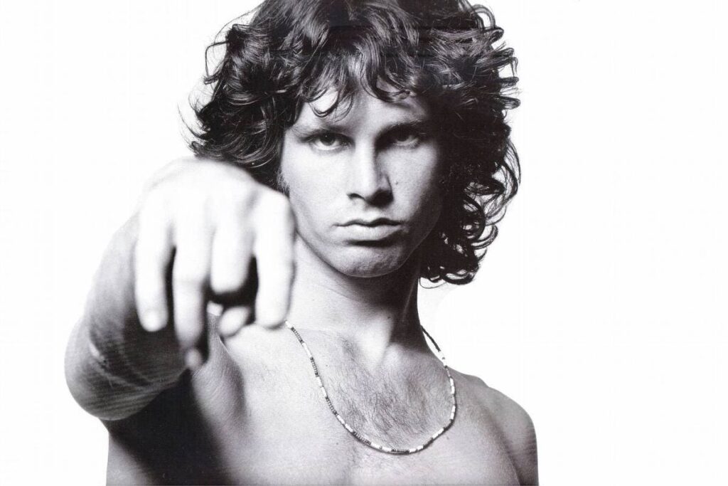 Jim Morrison sem barba encara a camera com seu olhar cortante