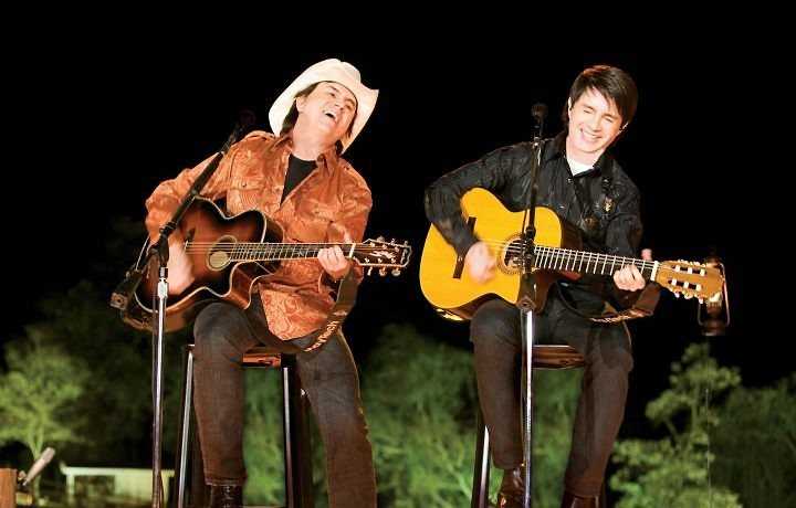 Chitãozinho e Xororó cantando e tocando violão