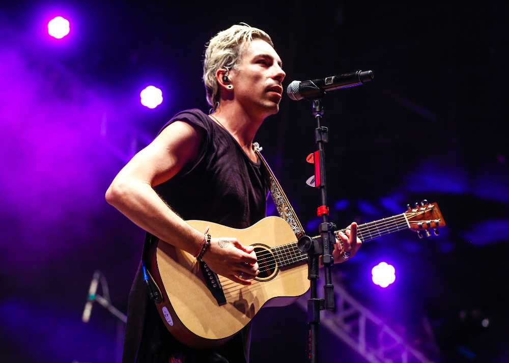 Di Ferrero cantando e tocando violão em show