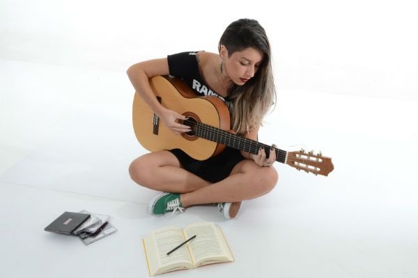 Coluna encurvada Menina toca violão com coluna curvada