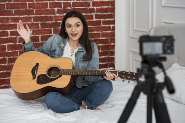 gravacao-aula-de-violao Jovem mulher gravando vídeo de como tocar violão