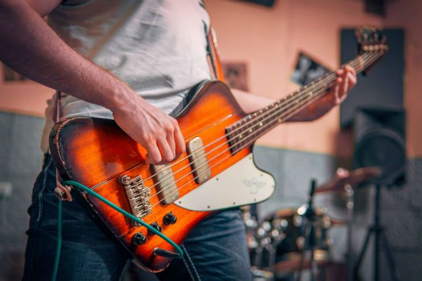 Bajista tocando bajo de cuatro cuerdas, modelo firebird