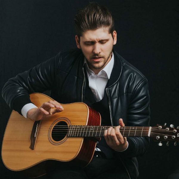 tecnica-fingerstyle_violao Homem sentado toca violão com a écnica fingerstyle