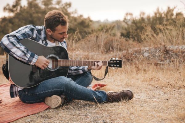 Músico faz um acorde complexo no violão