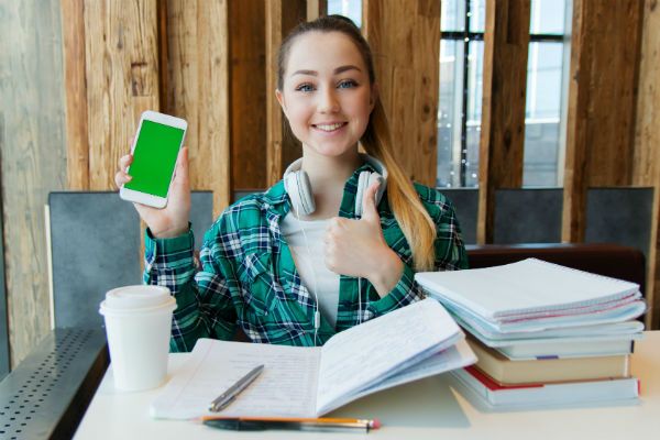 Menina jovem, estuda em casa e ouve música