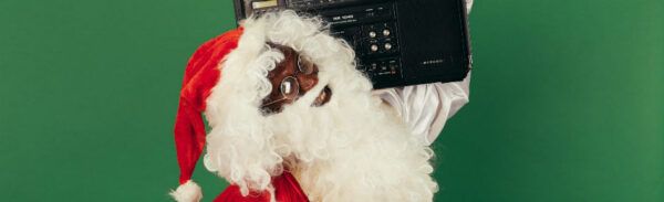 Papai Noel curtindo música em um sistema de som típico dos anos 80